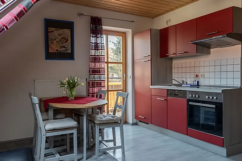 Küche und Frühstücksbereich mit Tür zum Balkon